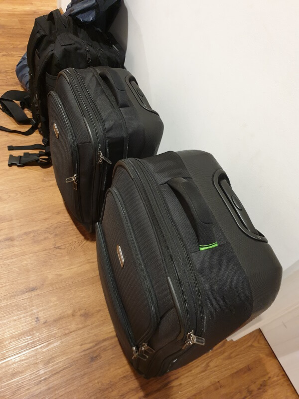 Zwei schwarze Koffer und ein schwarzer Rucksack im Flur