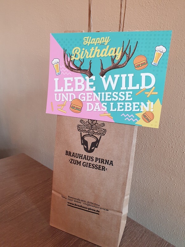Geburtstagsgeschenk vom Restaurant; Glückwunschkarte, auf der steht: Happy Birthday! Lebe wild und genieße das Leben!