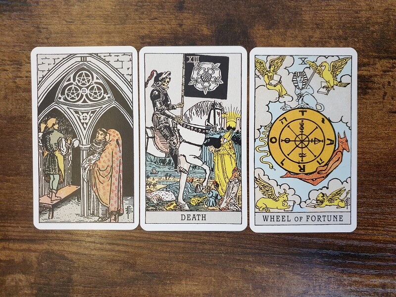 Psychologisches Tarot: 3 Tarotkarten auf einem Holztisch