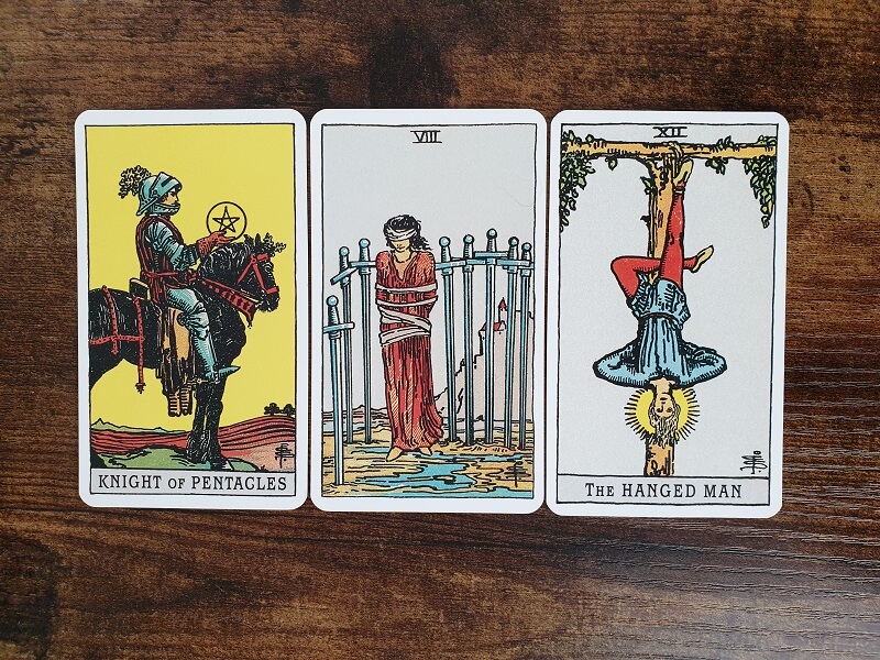 Psychologisches Tarot für empathisches Abgrenzen: 3 Tarotkarten auf einem Holztisch