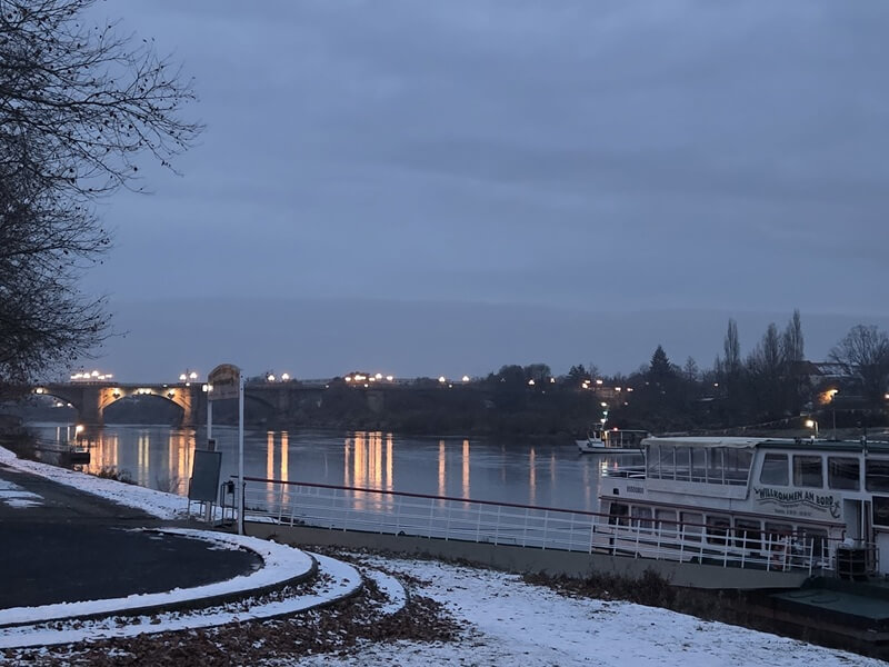 Winter an der Elbe: Schnee, Fähre und beleuchtete Stadtbrücke