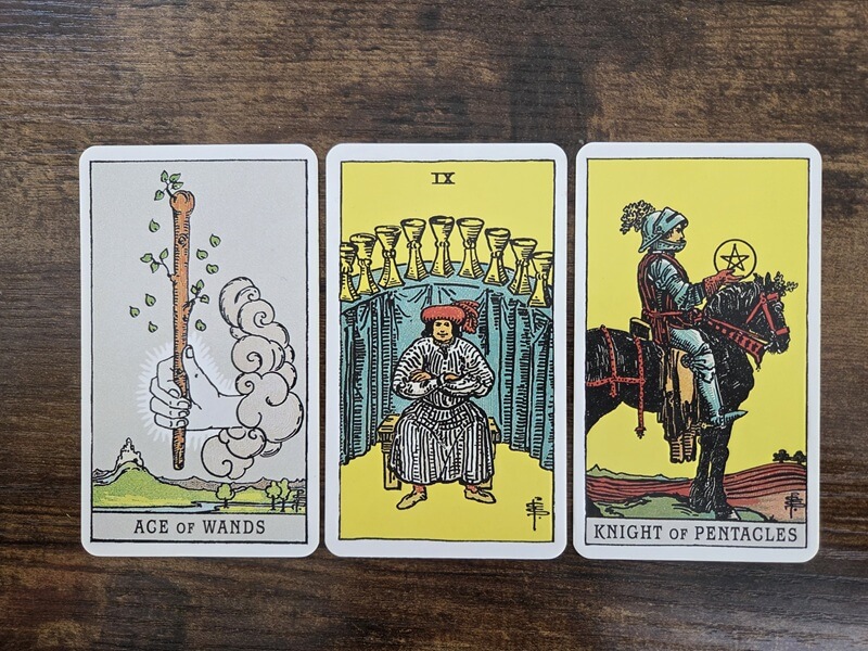 Psychologisches Tarot für empathisches Abgrenzen: 3 Tarotkarten auf einem Holztisch zum Thema „Wenn Gründlichkeit zur Mauer wird: Über den Wunsch, alles richtig zu machen“