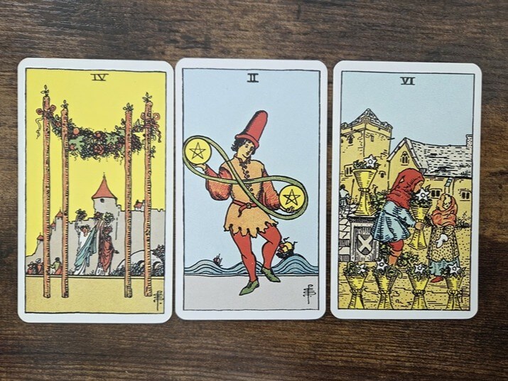 Psychologisches Tarot für empathisches Abgrenzen: 3 Tarotkarten auf einem Holztisch zum Thema Reizüberflutung im Social-Media-Feed