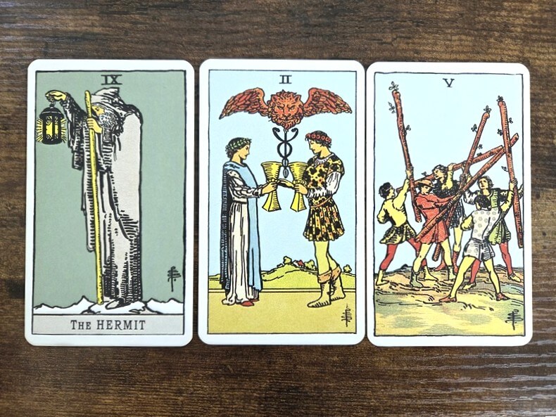 Psychologisches Tarot für empathisches Abgrenzen: 3 Tarotkarten auf einem Holztisch zum Thema „Warum strengt mich der Arbeitsalltag so an?“