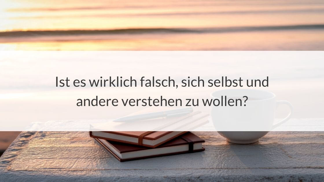 Notizbuch, Stift und eine Kaffeetasse auf einem Holztisch am Strand bei Sonnenuntergang. Darüber liegt der Text: „Ist es wirklich falsch, sich selbst und andere verstehen zu wollen?“